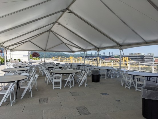 Tables outside on the fourth floor roof with a yellow bridge in the background