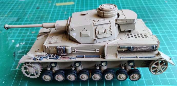 A sand yellow -painted 1:35 scale model of a German Panzer IV Ausf. F2 with DAK markings, without its tracks. Model is seen from the left side.