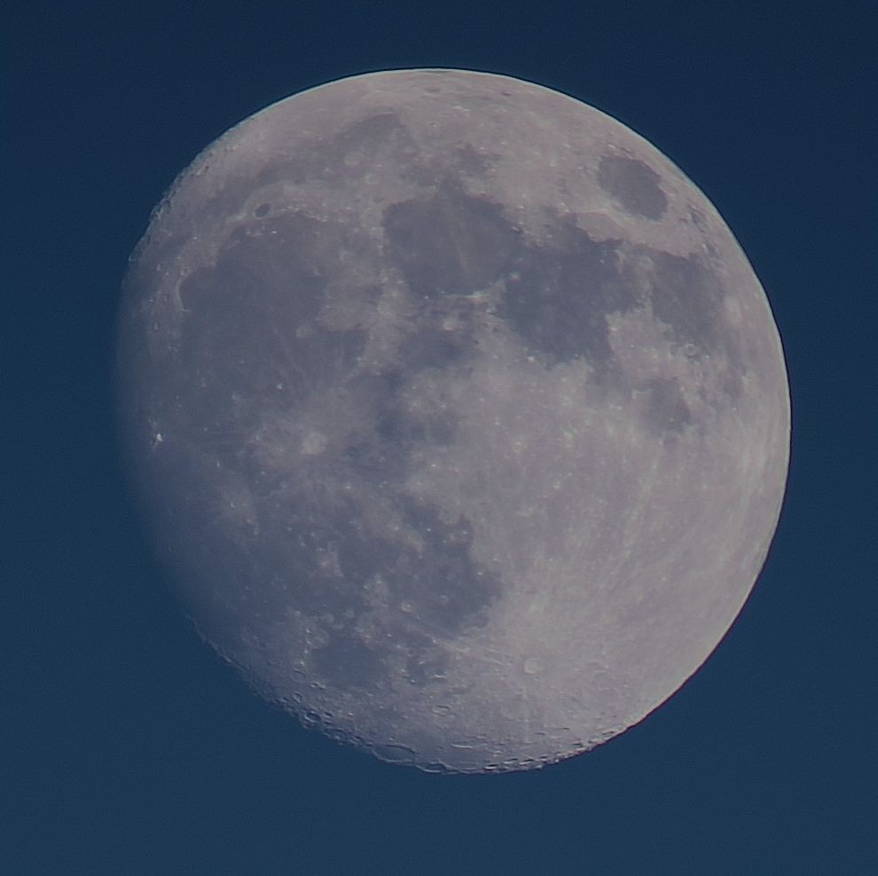 The Moon at waxing Gibbous phase on a blue sky background, 