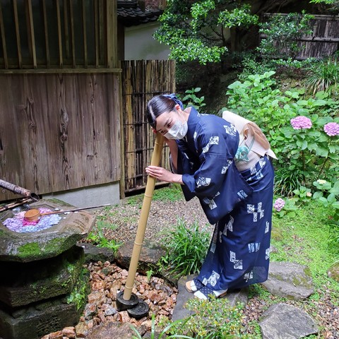 Nao-san listens to a suikinkutsu at Yokoku-ji. Water trickles from a water basin into a jar buried underground...it creates a tinkling sound like a harp.