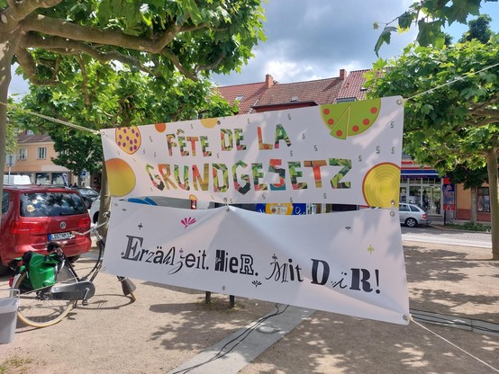 Banner mit der Aufschrift "Fête de la Grundgesetz - Erzählzeit. Hier. Mit Dir" hängen auf dem Marktplatz in Lübben.