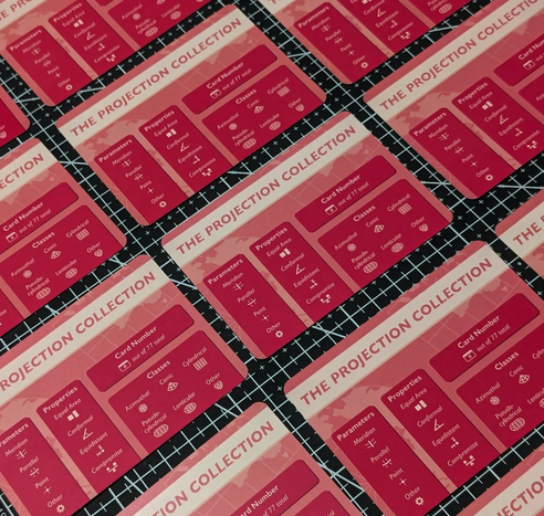 Several cards showing the reverse side of The Projection Collection cards that have information about the card's number, map projection parameters, properties, and class.