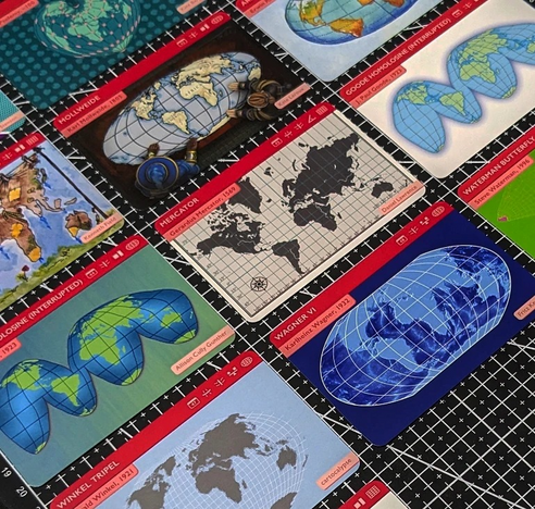 A set of cards from The Projection Collection showing different map projections such as Mercator, Wagner VI, and Mollweide.