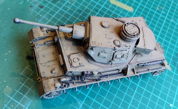 A 1:35-scale Panzer IV model painted sand yellow, after a pin wash applied on most of the surfaces, seen from above left.