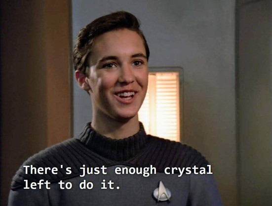 TNG scene. Young Ensign Wesley Crusher (the boy?) is standing in grey uniform and smiling a giddy happy golly shucks smile. Closed caption reads, "There's just enough crystal left to do it."