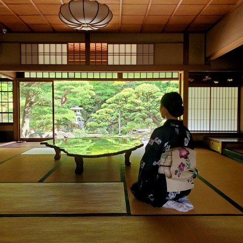 Nao-san relaxes in the sitting room at Omuro-tei. Photographers enjoy snapping photos of the green garden reflected in the polished table.