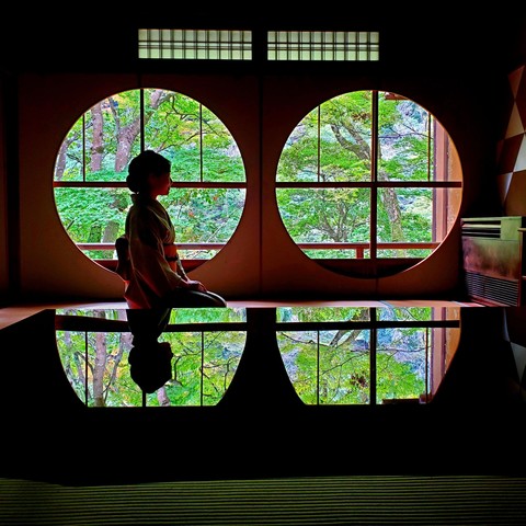 Nao-san at Yusai-tei. Once a high class inn, the space is now an exhibition space for kimono dyeing. The building is famed for its round windows that look out onto lush green trees in spring.