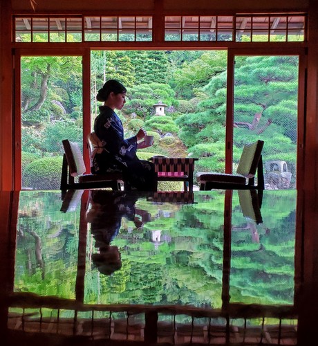 Nao-san enjoys tea at Omuro-tei. The building's highly polished tables have become a favourite with photographers, who capture the garden's lush green in the mirrored surface.