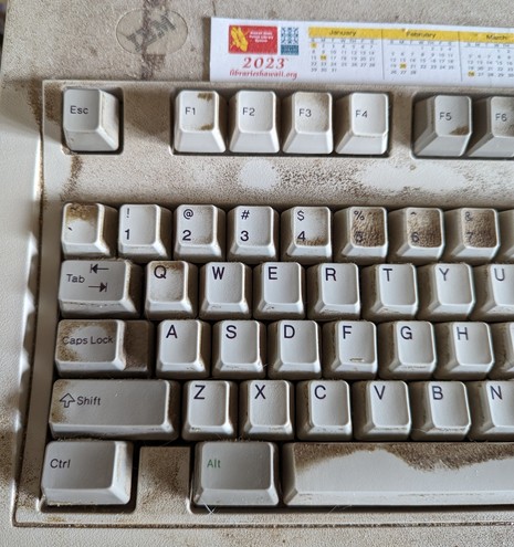 Left part of a beige IBM 101-key AT keyboard with accumulated grime on keys and keyboard.