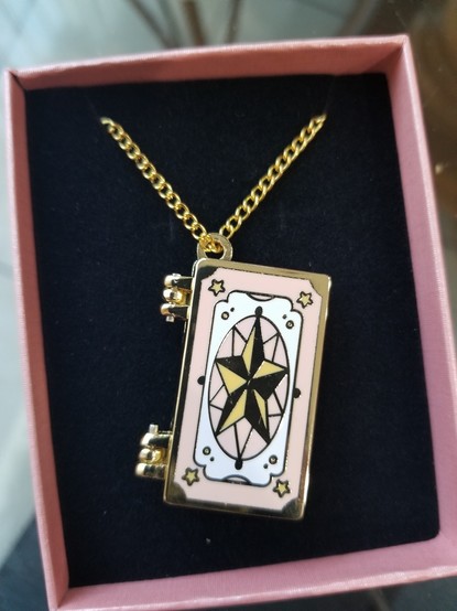 A locket that looks like the card captor sakura clown card book