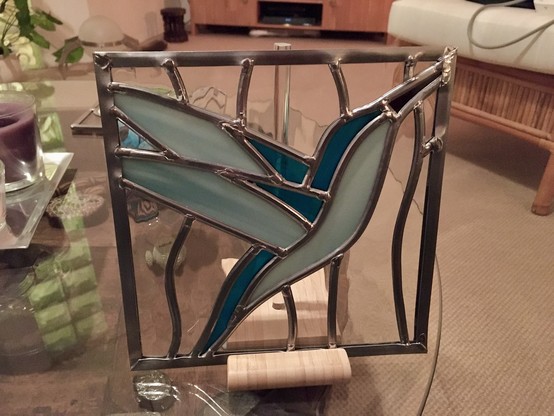 Stained glass panel with bird in dark and light blue. 