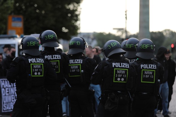 Polizisten vor einer Gruppe von Gegenprotest. 