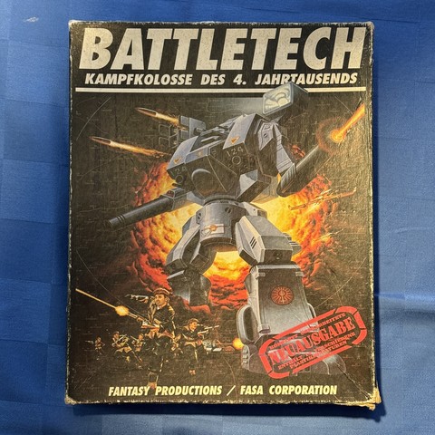 Battletech-Verpackung auf einer Tischdecke liegend. 