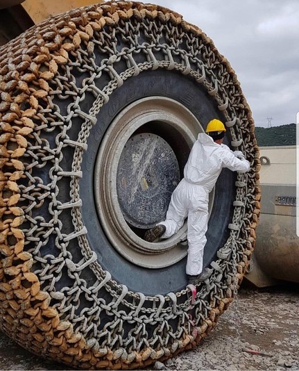 Operario subido a la cadena que está colocando sobre una rueda gigante.