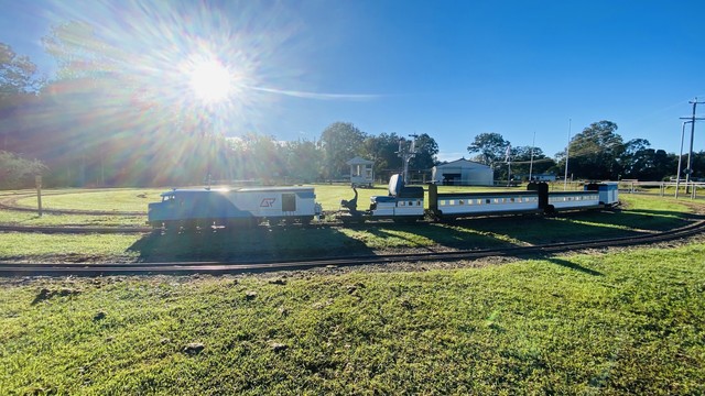 A miniature train with a locomotive and two carriages 