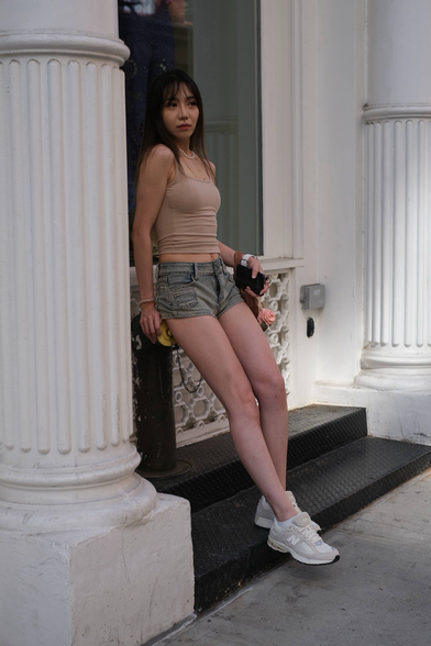Girl leaning against white wall 