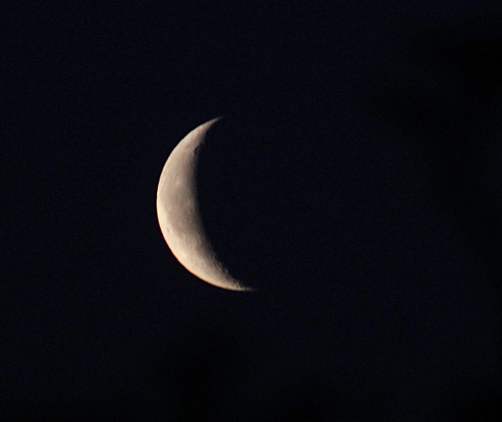 The Moon at waning crescent phase on a dark background. 