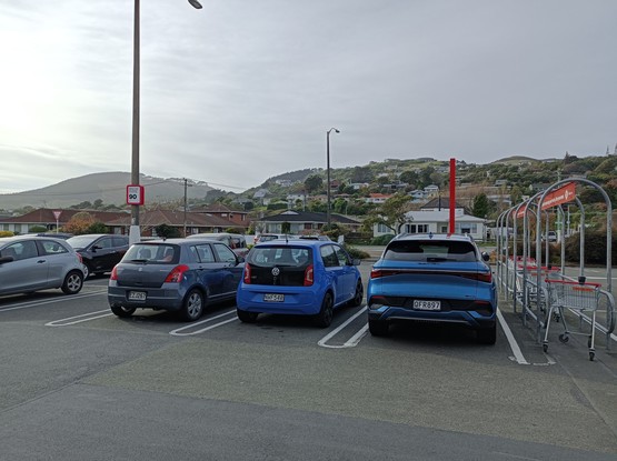 Volkswagen Up 5-türig in blue, between a Suzuki Swift and a BYD Yuan Plus. 