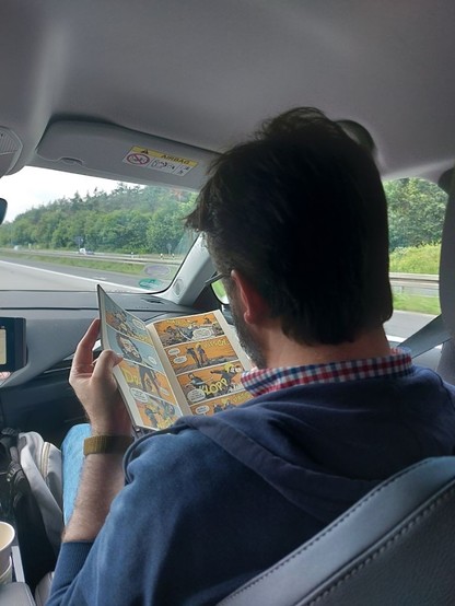 Ne. Sitting in the car. Reading comicbooks.