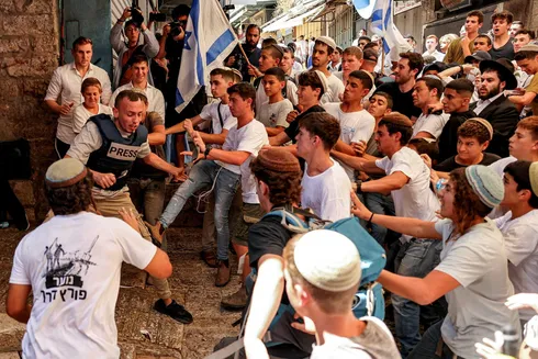 Israeli fascist youths attack a journalist during Jerusalem Day, Wednesday.Credit: AFP