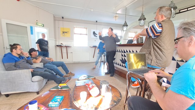 Audience of the performance presentation and discussion in chilled mode in the "Fireplace room" of our conference location. Tobias presenting in front of the bar counter.