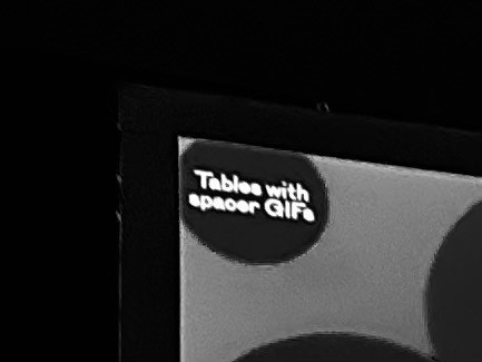 A tiny part of a presentation slide, that shows a bubble with text “Tables with spacer GIFs”