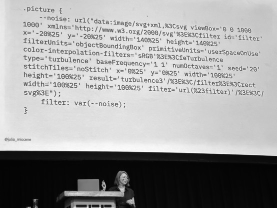 Julia Miocene on CSS Day presenting the CSS for applying a SVG filter to add some noise to a picture. (It is complex svg markup that is intended for general understanding rather than to be adopted specifically)
