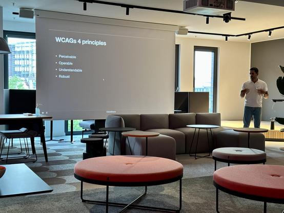 A photo of Daniel presenting. The slide says

WCAGs 4 principles

• Perceivable
• Operable
• Understandable
• Robust