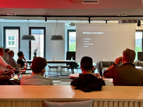 A photo of people sitting and watching Daniel’s presenting in the Parship Group „Heartquarter“