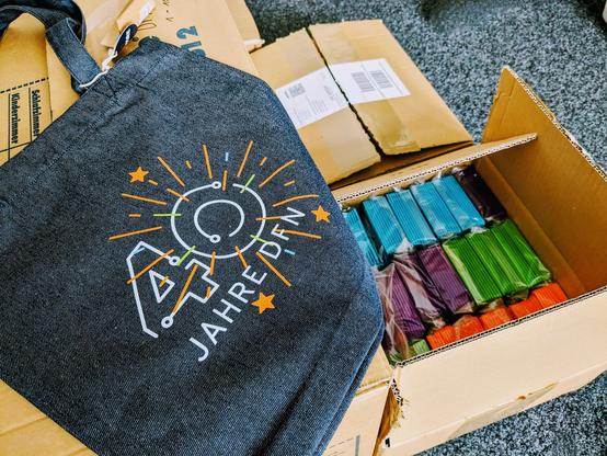 Zu sehen ist der 40-Jahre-DFN-Beutel, aus recyceltem Jeansstoff, der für die Feier eingepackt wird. Fotos: DFN