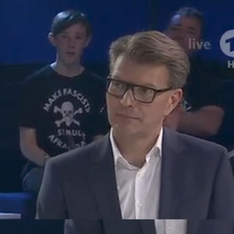Ein junger Mensch im Publikum mit einem FCSP T-Shirt und der Aufschrift "make racists afraid again".
