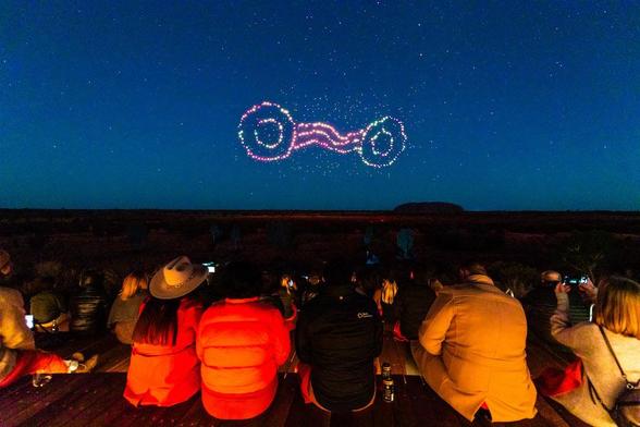 As spectators watch, drones blossom into patterns to the music of Wintjiri Wiru. Photo credit: Voyages Indigenous Tourism Australia.