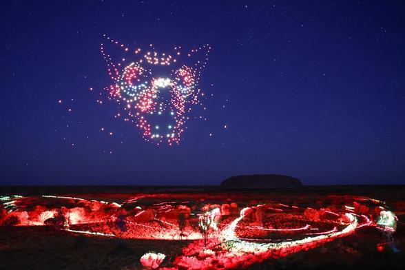 Hundreds of drones create the image of the evil Kurpany while Uluru stands silent in the distance  Photo credit: Voyages Indigenous Tourism Australia.