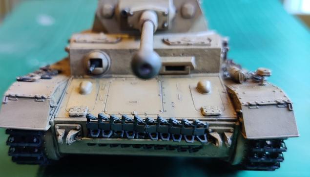 A partially weathered 1:35 scale model of a Panzer IV painted in Deutsche Afrika Korps' sandy yellow, seen from the front.