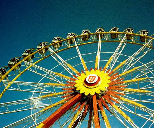 Grainy picture of a Ferris wheel in front of a blue sky