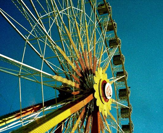 Grainy picture of a Ferris wheel in front of a blue sky