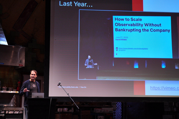 David Gildeh in front of a screen with a slide showing himself in front of a screen from a year ago