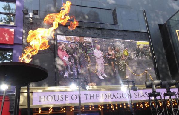 Big screen on front of Odeon cinema showing interview with Ryan Condal, with flame foreground.