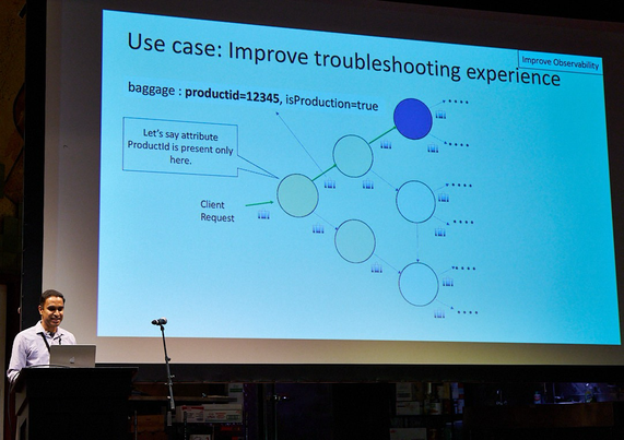 Speaker in front of a slide showing how metadata propagates through a dependency graph that enables better context