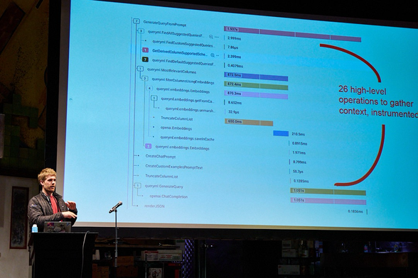 Speaker in front of slide showing a waterfall trace of context gathering in an AI application