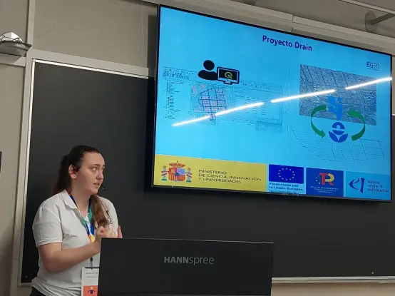 María delante de una pantalla con una presentación