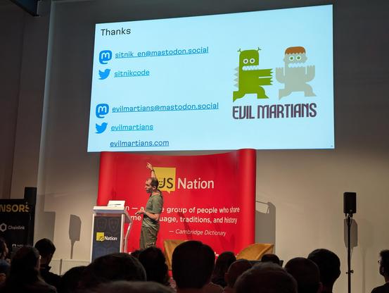 Andrey on the stage. Last slide of the presentation is above him.
