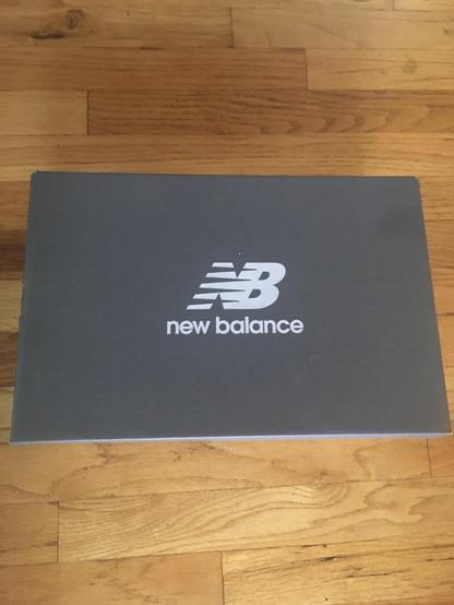 A shoebox, with “NB” logo and the name “new balance”
