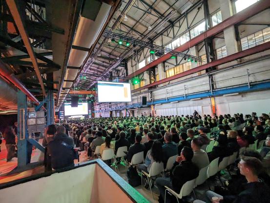 Old factory hall full of attendees.