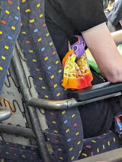 Foulard arc en ciel sur un siège d'une voiture EW-IV dans un train rempli de personnes queer entre Bâle et Zürich.