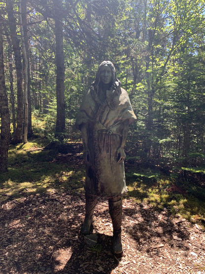 Sculpture of a Beothuk woman in a Birch Forest.