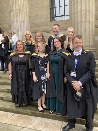 EduAT graduates on the Caird hall steps with Rohan in academic dress