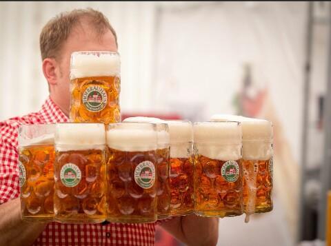 Man met n boel tweeliter glazen vol bier. 