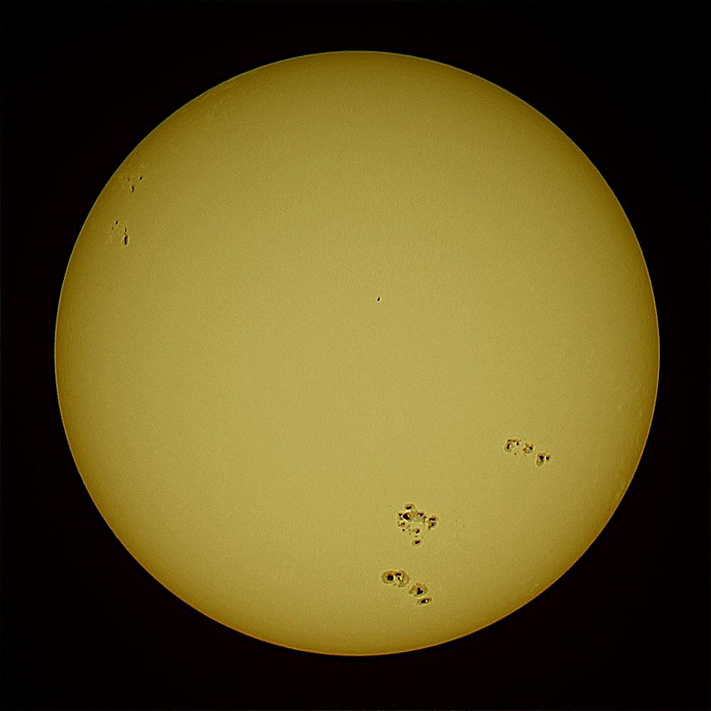 The yellow Sun and spots on a dark background. 