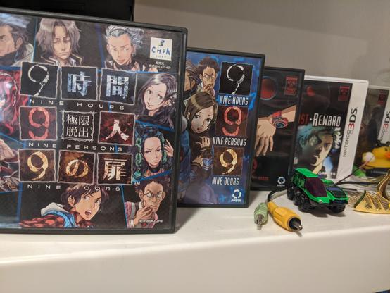 The Japanese copy of 999 sits on a shelf with a U S copy, a U S reprint copy, and 3DS copies of Virtue's Last Reward and Zero Time Dilemma.